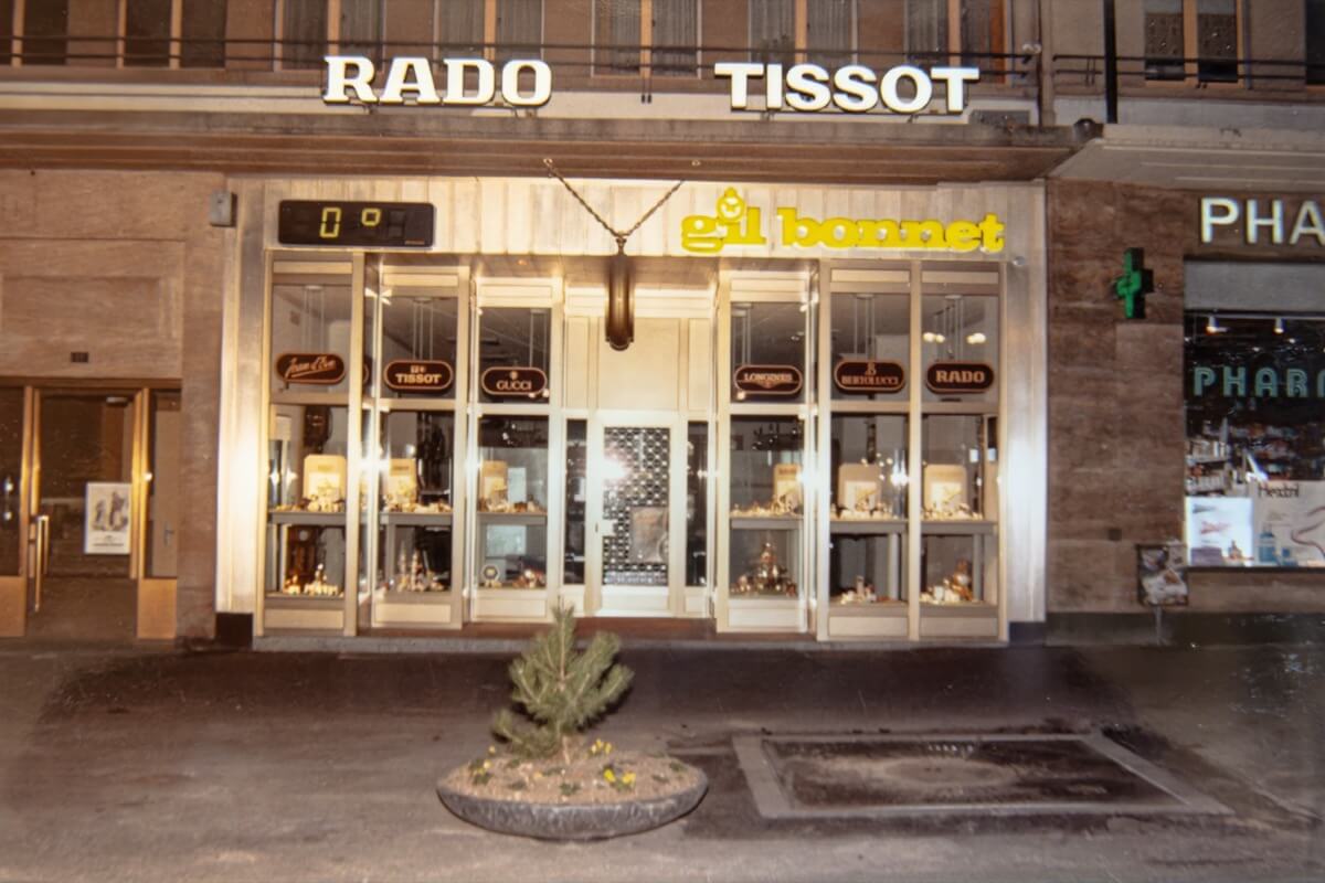 Nouvelle façade rénovée de Gil Bonnet avec vitrines modernes, enseignes lumineuses Tissot et Rado et logo jaune, vue de nuit.