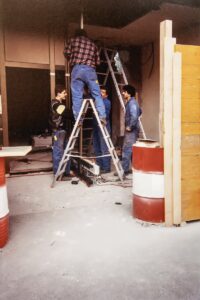 Travaux de rénovation de la boutique Gil Bonnet avec des ouvriers installant des structures métalliques à l'entrée.