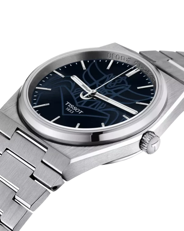 Vue de profil de la Tissot PRX UFO Robot Goldorak avec cadran bleu gravé du visage de Goldorak et boîtier en acier inoxydable.