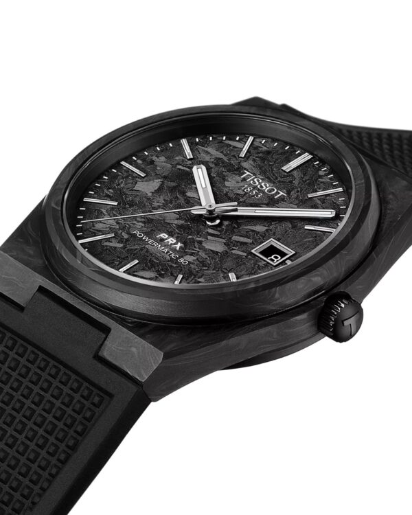Gros plan sur la montre Tissot PRX Powermatic 80 Carbone, avec cadran noir en fibre de carbone, boîtier noir mat et bracelet en caoutchouc structuré.