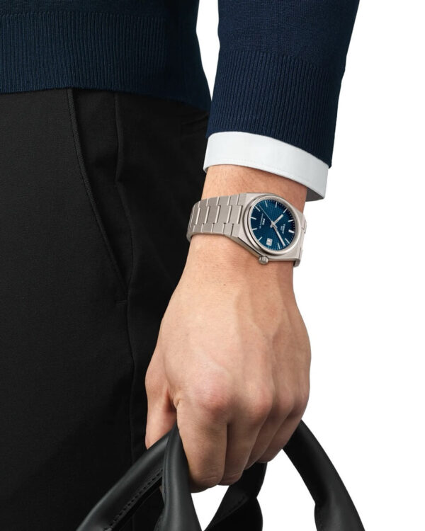 Montre Tissot PRX Powermatic 80 Titane avec cadran bleu portée au poignet, bracelet intégré en titane et design élégant.