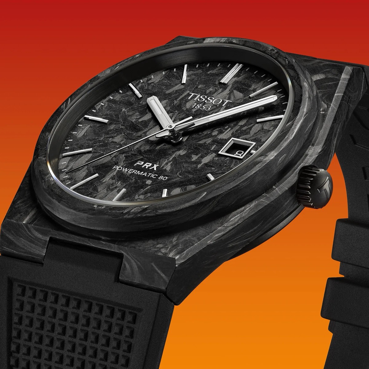 Gros plan sur la montre Tissot PRX Powermatic 80 Carbone, montrant le cadran noir texturé en fibre de carbone et le boîtier en composite noir sur fond dégradé orange.