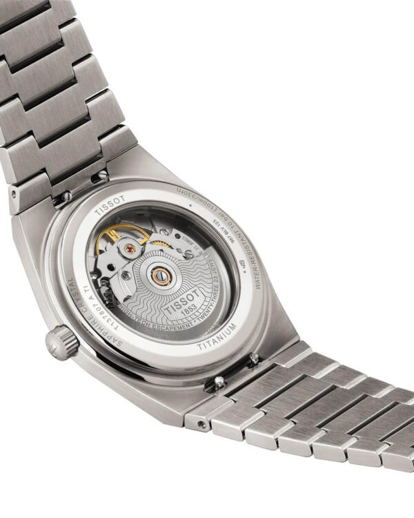 Vue du fond de boîtier de la montre Tissot PRX Powermatic 80 Titane, montrant le mouvement automatique à travers le verre saphir.